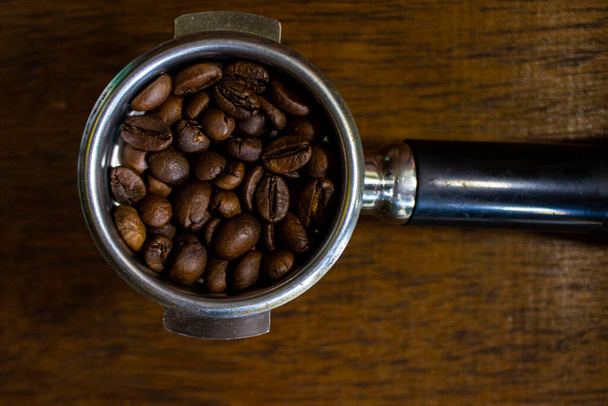 porta filter with ground coffee and coffee bean on table - Zdjęcie, obraz