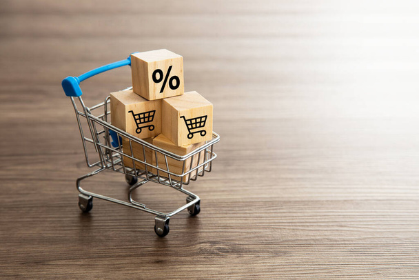 Supermarket carts with shopping cart, percentage icon on wooden cubes. Shopping concept. - Photo, Image
