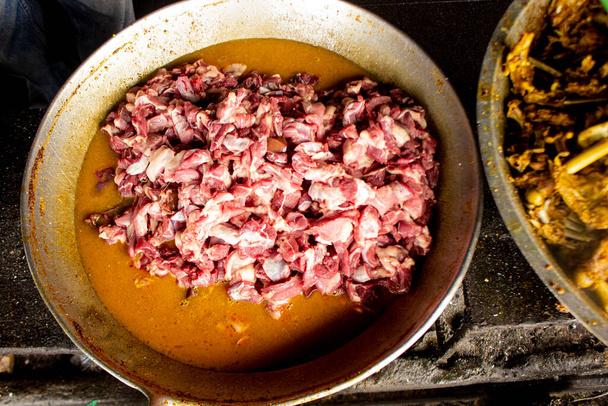 Traditional cooking raw meat with yellow curry or Tongseng in pan. Tongseng is traditional curry food from central java indonesia - Φωτογραφία, εικόνα