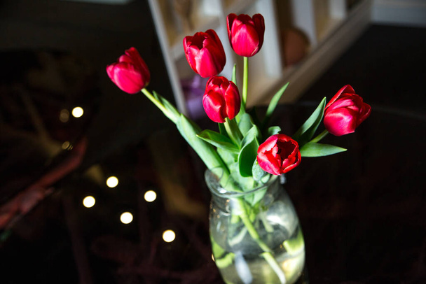 beautiful bouquet of tulips in a vase on a wooden table - Fotoğraf, Görsel