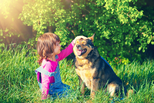 Little girl pets her dog - Foto, imagen