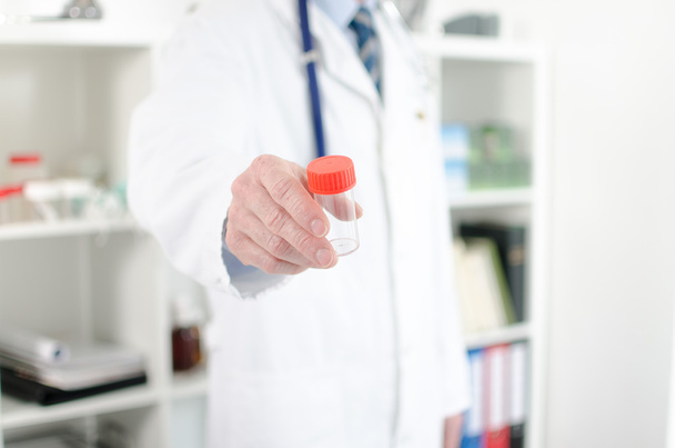 Médico sosteniendo un recipiente de muestra
 - Foto, imagen