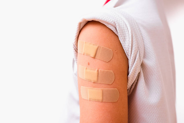 Poor recently vaccinated child with three band aids to feel good. - Foto, imagen