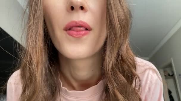 A young woman shows her tongue rolled up into a tube - Imágenes, Vídeo
