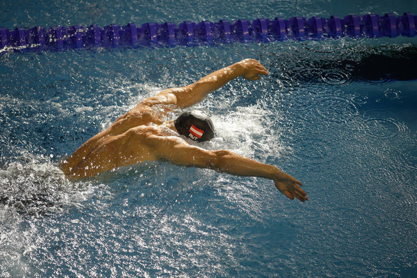 Otopeni, Romanya - 8 Temmuz 2022: Olimpik havuz kelebeği stilinde yüzen Avusturyalı profesyonel bir erkek sporcuyla ayrıntılar. - Fotoğraf, Görsel