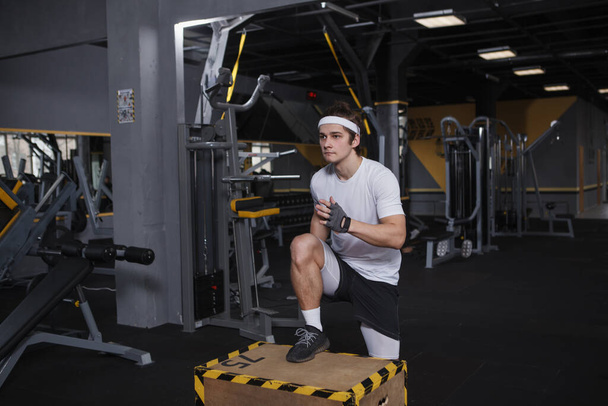 Focused male athlete exercising on jumping box - Foto, afbeelding