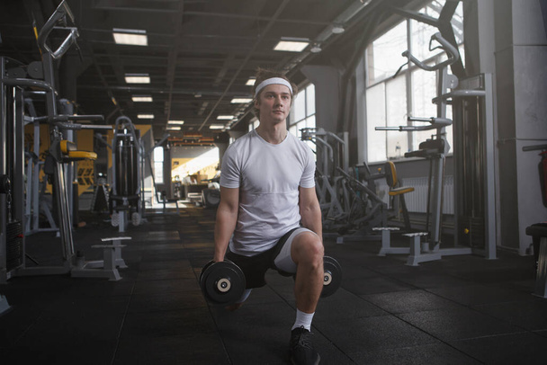 Full length shot of a sportsman doing weighted lunges with dumbbells - Foto, Imagem