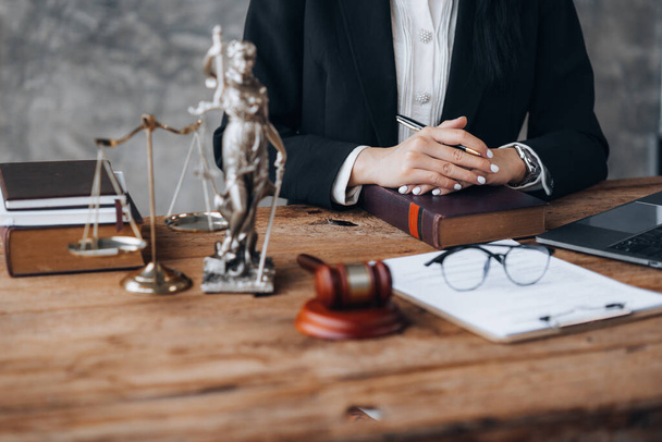 An Asian female lawyer is at her law firm, she is a lawyer advising on various litigation cases. To clients who are in trouble in the legal way. Concept of female lawyer and justice of the law. - Φωτογραφία, εικόνα