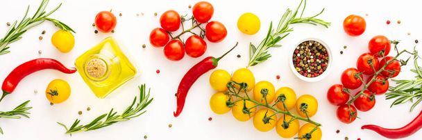 Gele en rode tomaten, hete paprika 's, rozemarijn en specerijen op een witte achtergrond, voedselbanner, bovenaanzicht - Foto, afbeelding
