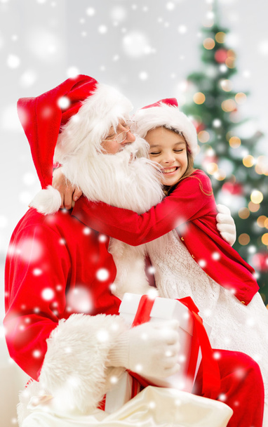 smiling girl with santa claus and gift at home - Zdjęcie, obraz