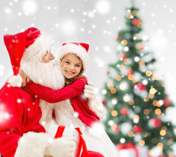 smiling girl with santa claus and gift at home - Valokuva, kuva