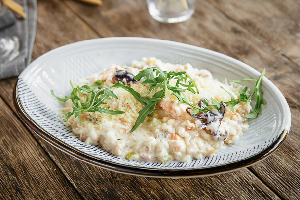 Portion of gourmet seafood risotto on wooden background - Fotoğraf, Görsel