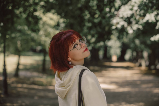 Tyylikäs punapää tyttö lasit syksyllä kausi puistossa - Valokuva, kuva