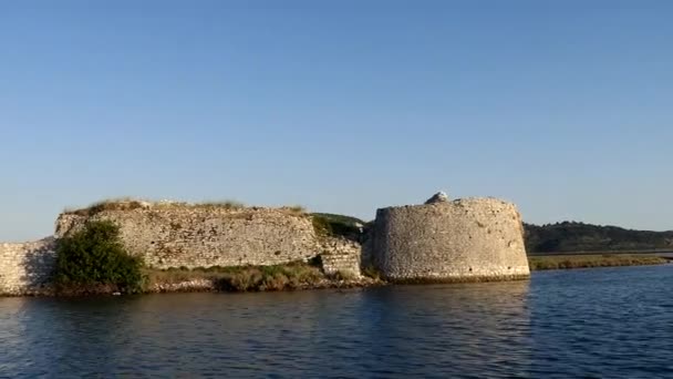 Ksamil, Albania A small motorboat approaches the Ali Pasha Castle on the coast. - Filmmaterial, Video