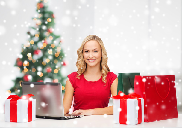 woman with gift boxes and laptop computer - Foto, Bild