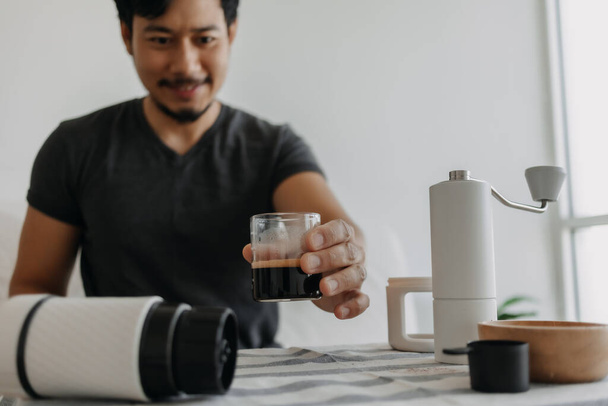 Asian man make and drink his own french press coffee. - Foto, Bild