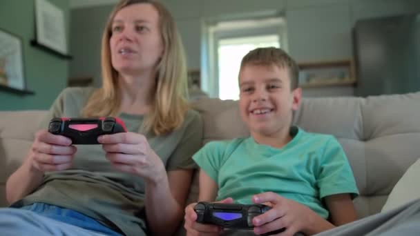 Oğlan ve anne evde video oyunu oynuyor, aile birlikte vakit geçiriyor, mutlu bir ilişki, online eğlence ve boş zaman aktivitesi., - Video, Çekim