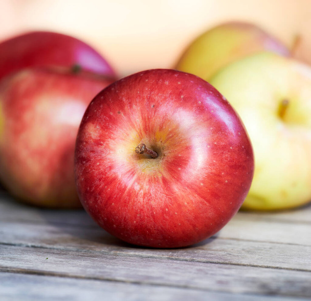 El primer plano de las manzanas rojas frescas en una mesa. Deliciosa y orgánica fruta recogida en su madurez y en temporada para disfrutar con vitaminas para una sana inmunidad. Productos nutritivos para una dieta vegana o vegetariana. - Foto, imagen