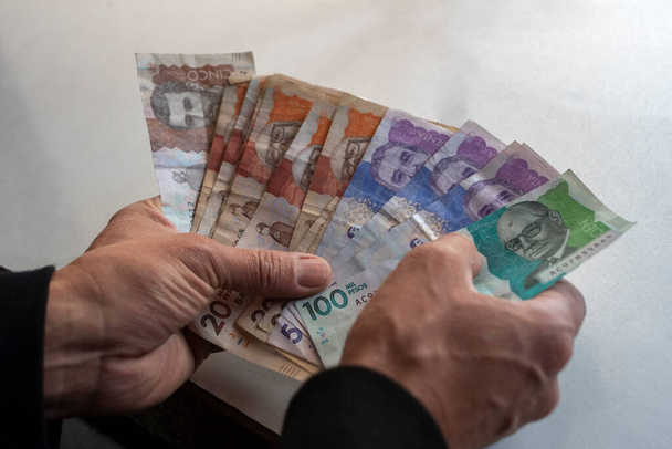 Men's hands with Colombian Pesos  - Фото, изображение