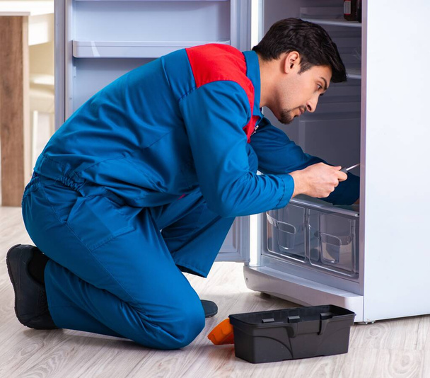 O homem que conserta a geladeira com o cliente - Foto, Imagem