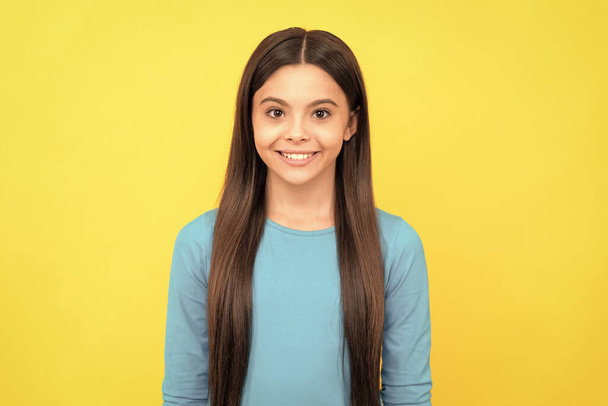 cheerful teen girl with long hair on yellow background, fashion. - Photo, Image