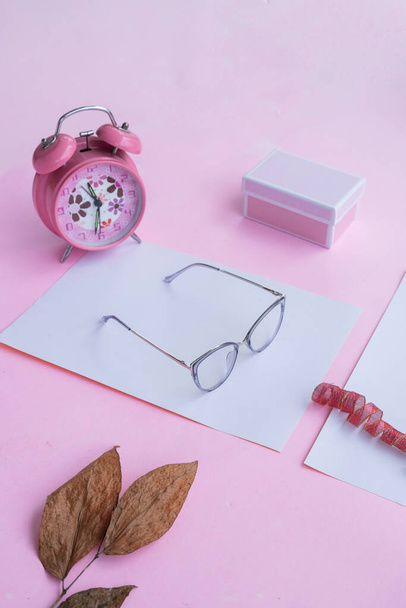 Fashion and beauty concept lying flat with square glasses, women's accessories on pink background. - 写真・画像