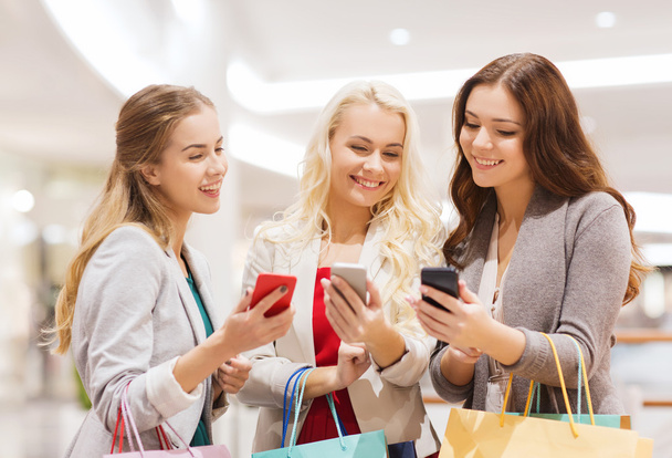 happy women with smartphones and shopping bags - Foto, Bild