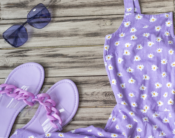 Femmes vêtements d'été dans les tons violets : lunettes, robe, pantoufles de plage. Concept commercial. Aménagement plat, espace pour le lettrage. - Photo, image