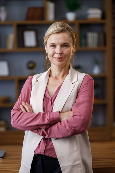 Portrait of beautiful blondie woman looking at camera and smiling. Adult stylish businesswoman at workplace in office. Successful confident female leader close up face headshot, front portrait. - Foto, afbeelding
