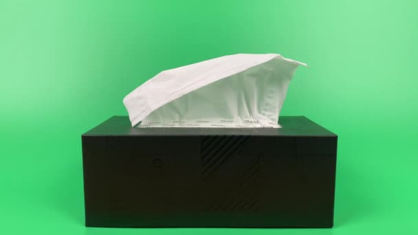 a mão de uma pessoa retira um pedaço de tecido da caixa de papel tissue isolado no fundo verde. - Filmagem, Vídeo
