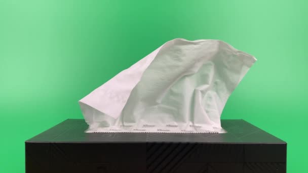 a person's hand pull out a piece of tissue from tissue paper box isolated on green background. - Filmati, video