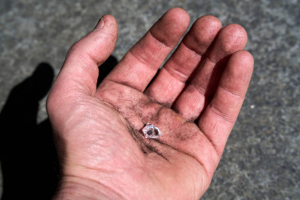 Hand mit einem simulierten Diamanten, der vorgibt, auf der Erde gefunden worden zu sein. Hochwertiges Foto - Foto, Bild