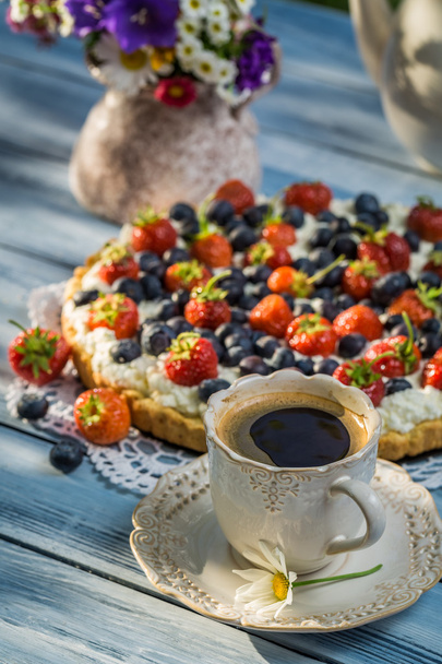 Fruit tart served with coffee in the summer garden - Фото, изображение