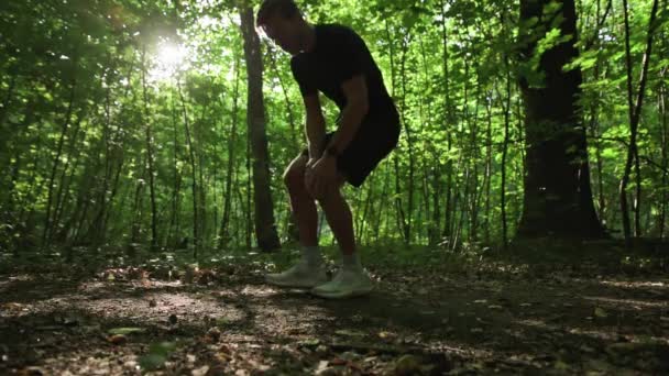 Man has knee pain during morning running at park. Injury during outdoor sports. Fitness, cardio concept - Video, Çekim