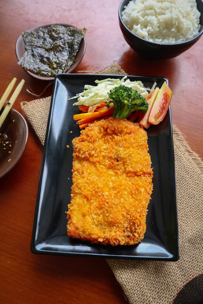 chicken katsu don is japanese food served with soy sauce on table - Fotó, kép