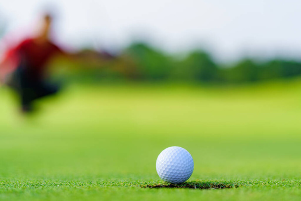 Golfista putt bola de golfe em buraco no verde no campo de golfe. - Foto, Imagem