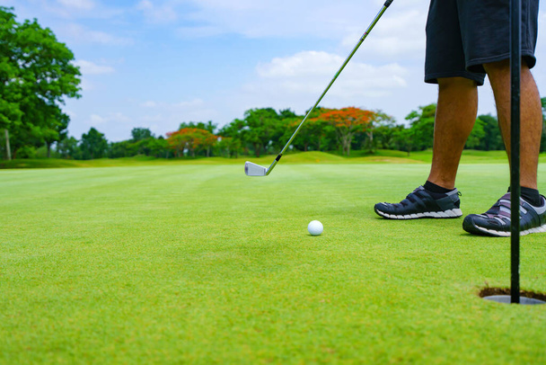 Golf putt piłka golfowa do otworu na zieleni na polu golfowym. - Zdjęcie, obraz