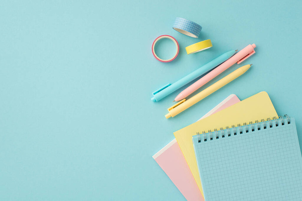 Back to school concept. Top view photo of colorful school supplies adhesive tape pens and notepads on isolated pastel blue background - Zdjęcie, obraz