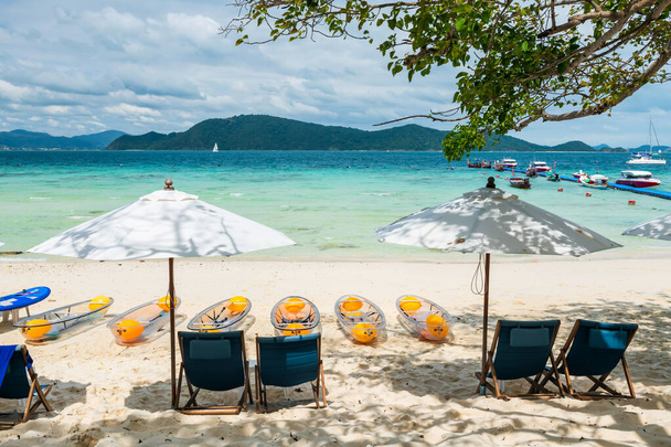 Plážové lehátka, slunečník, kánoe lodě na bílé písečné pláži s tyrkysovým mořem na Hej ostrov, Phuket, Thajsko. Slavná destinace nebo letní prázdninová aktivita Siamu. - Fotografie, Obrázek