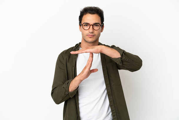 Caucasian handsome man over isolated white background making time out gesture - Valokuva, kuva