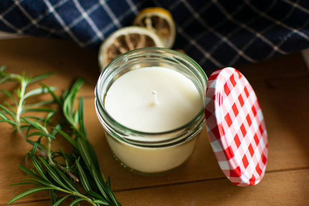 Scented candle with a scent of lemon and rosemary in a screw-top jar. closeup - Foto, Imagem