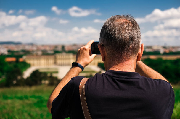 A tourist in the center of a European city takes pictures of the sights - Фото, изображение