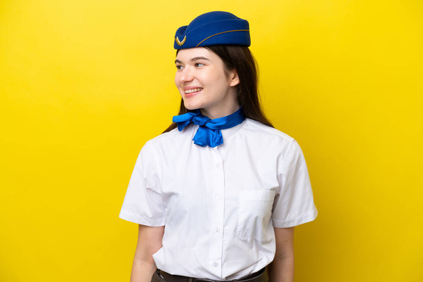 Αεροσυνοδός Ρωσική γυναίκα απομονωμένη σε κίτρινο φόντο αναζητούν πλευρά - Φωτογραφία, εικόνα