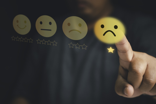 Customer unhappy service and Satisfaction concept ,Client touching virtual screen on Smiley face icon to give satisfaction in service. 1-star rating very dissatisfied - 写真・画像