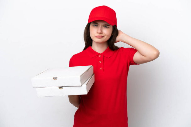 Молодая российская доставка пиццы собирает коробки пиццы изолированы на белом фоне с сомнениями - Фото, изображение
