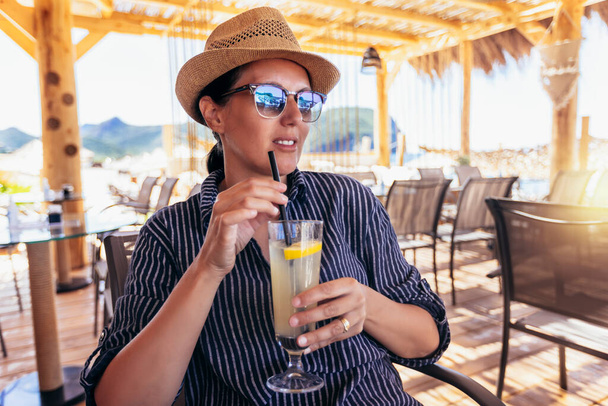 Woman drink summer cocktail on sea background. - Photo, Image