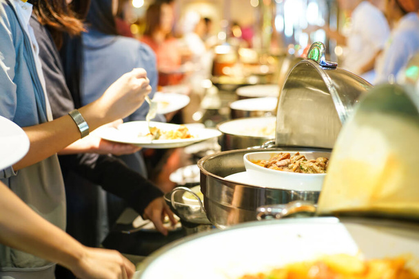 Группа людей захватывает шведский стол в ресторане после семинарии - Фото, изображение