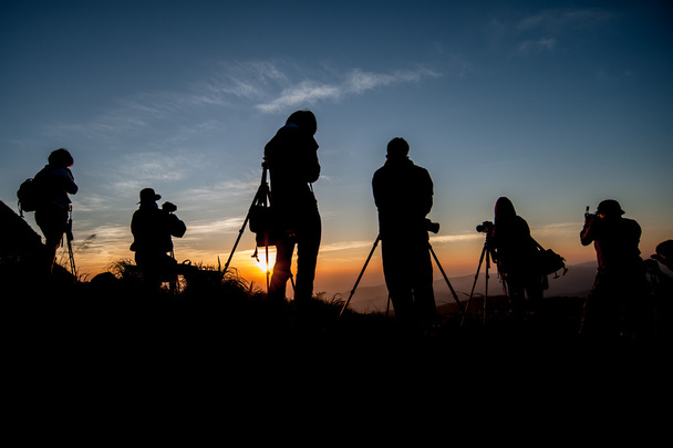 Силуэт фотографа, фотографирующего пейзаж на восходе солнца
 - Фото, изображение