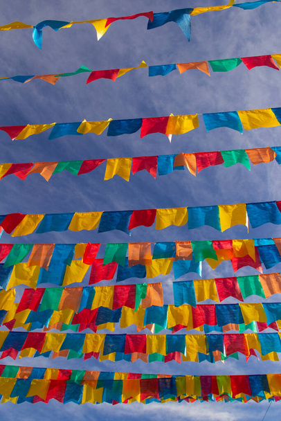 Несколько бельевых верёвок с тканевыми флагами на фоне голубого неба для июньского праздника - типичный бразильский фестиваль. "Ферилья"". - Фото, изображение