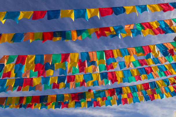 Varios tendederos con banderas de tela contra el cielo azul para la fiesta de junio - típico festival brasileño. "Cuadrilha". - Foto, imagen